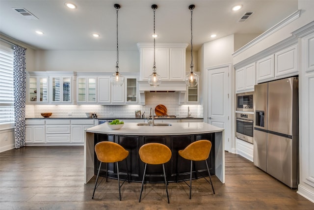 kitchen featuring a sink, visible vents, appliances with stainless steel finishes, and a center island with sink