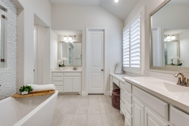 bathroom with lofted ceiling, two vanities, a freestanding bath, a sink, and tile patterned floors