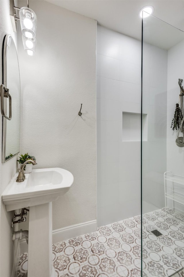 full bath with tile patterned floors, baseboards, and walk in shower