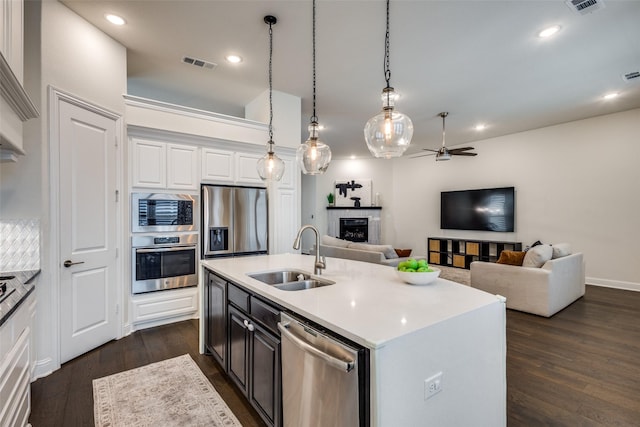 kitchen with visible vents, dark wood-type flooring, light countertops, stainless steel appliances, and a sink