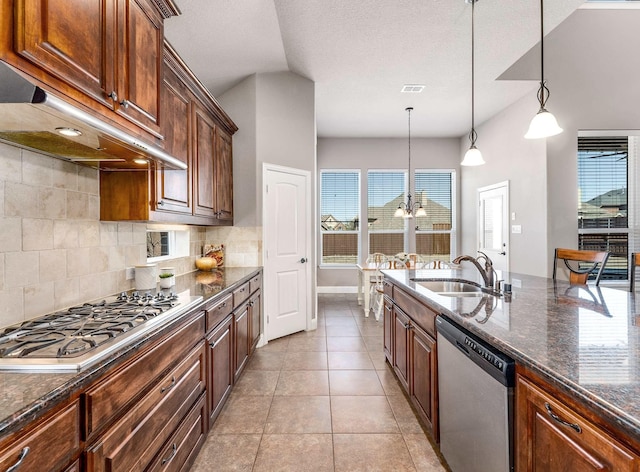 kitchen featuring a sink, decorative backsplash, under cabinet range hood, appliances with stainless steel finishes, and decorative light fixtures