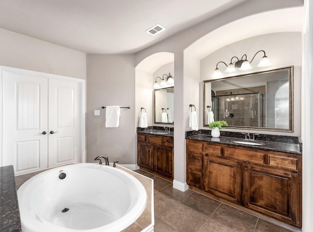 full bath featuring a shower stall, a bathtub, visible vents, and a sink