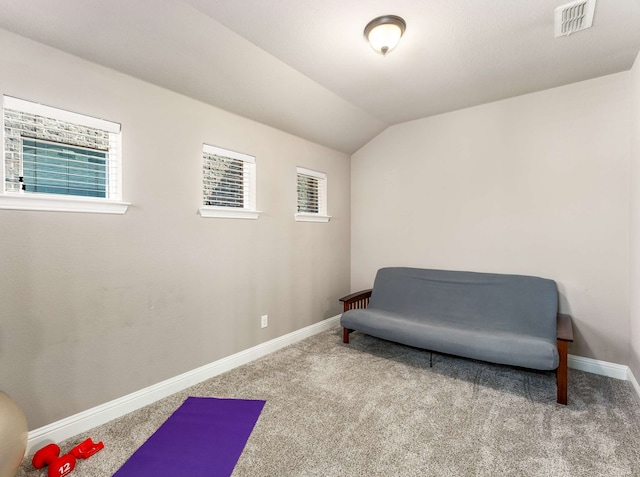 living area featuring visible vents, baseboards, carpet flooring, and vaulted ceiling