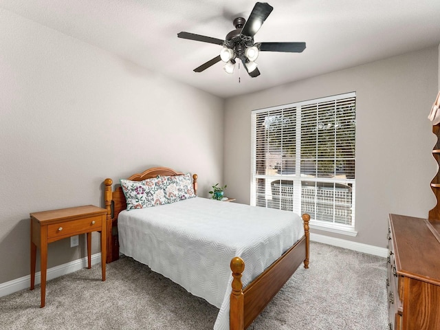 bedroom featuring light colored carpet, baseboards, and ceiling fan