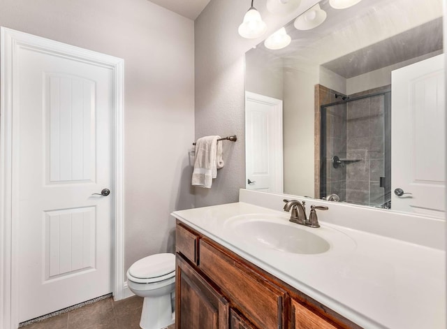 full bathroom featuring tiled shower, toilet, and vanity