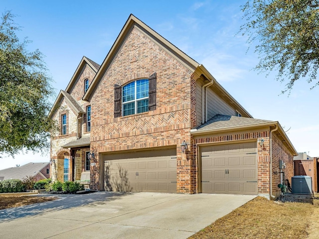 traditional home with brick siding, central air condition unit, driveway, and an attached garage