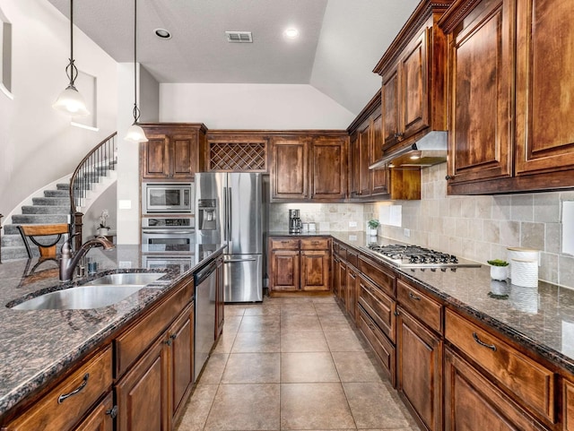 kitchen with visible vents, under cabinet range hood, a sink, stainless steel appliances, and decorative backsplash