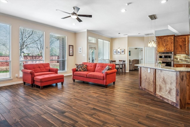 living area featuring dark wood-type flooring, plenty of natural light, crown molding, and recessed lighting