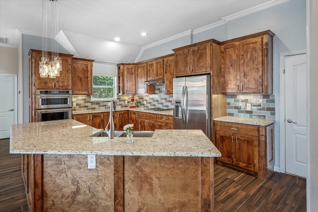 kitchen with under cabinet range hood, a sink, backsplash, stainless steel appliances, and vaulted ceiling