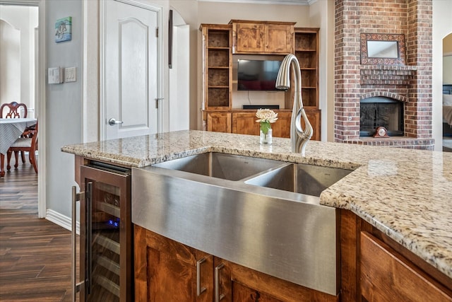 kitchen featuring a sink, wine cooler, dark wood finished floors, brown cabinetry, and open shelves