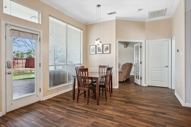 dining space with baseboards, dark wood-style floors, visible vents, and ornamental molding