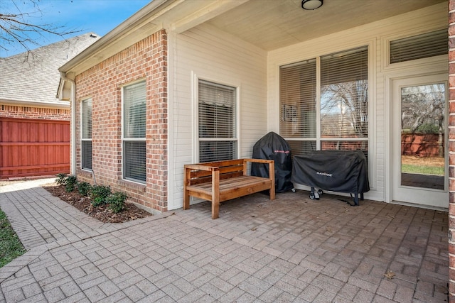 view of patio with a grill and fence