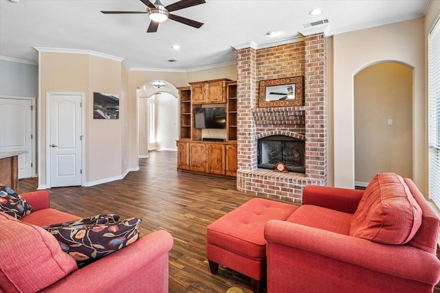 living room featuring baseboards, dark wood finished floors, arched walkways, ceiling fan, and a brick fireplace