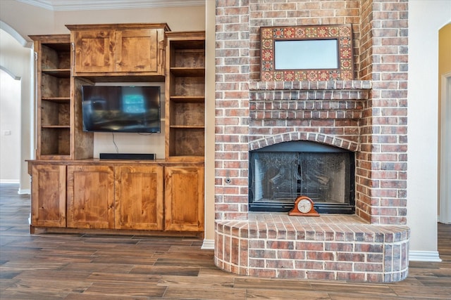 unfurnished living room with wood finished floors, baseboards, and ornamental molding