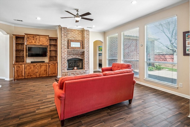 living area with visible vents, baseboards, dark wood-style flooring, ornamental molding, and a brick fireplace