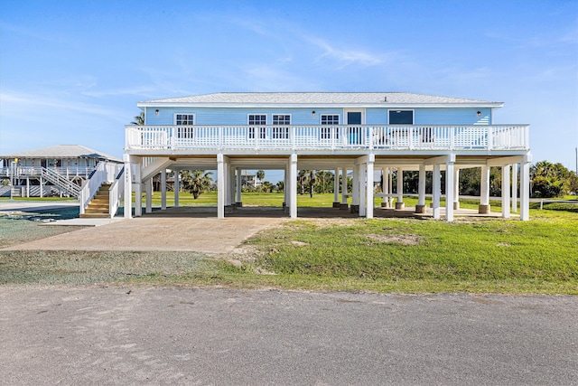 view of front of home with a carport, a front lawn, and roof with shingles