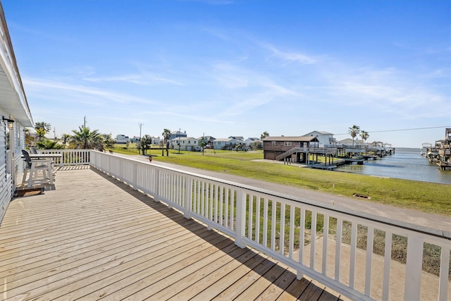 wooden terrace with a residential view, a yard, and a water view