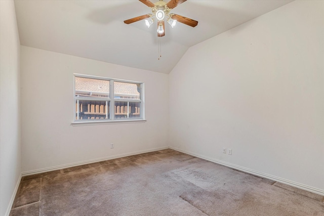 carpeted empty room featuring lofted ceiling, baseboards, and ceiling fan