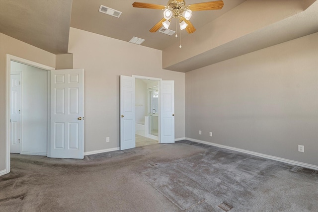 unfurnished bedroom featuring visible vents, carpet flooring, baseboards, and lofted ceiling