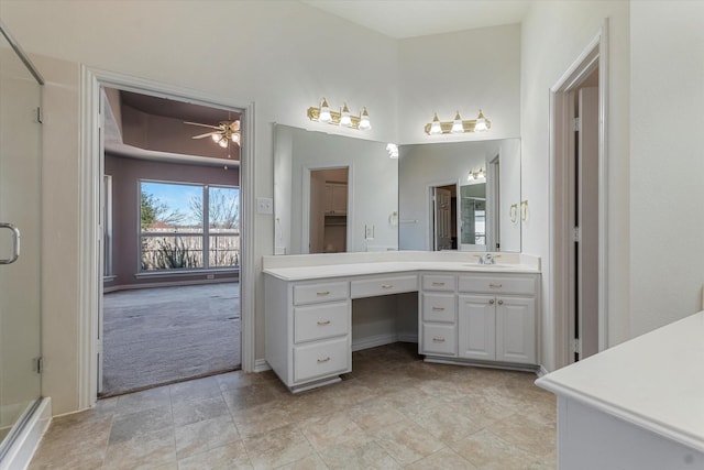 full bath with baseboards, a shower stall, ceiling fan, and vanity