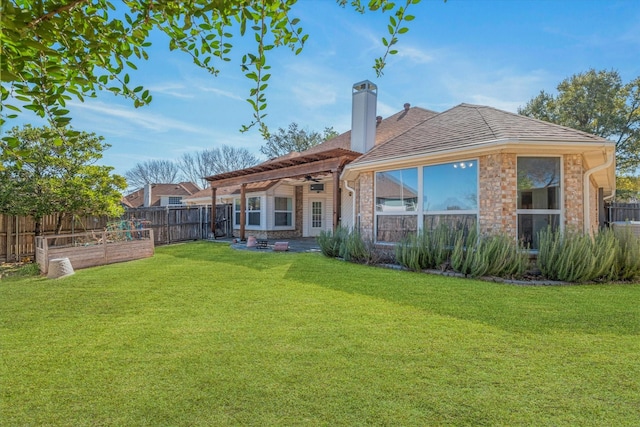 rear view of house featuring a vegetable garden, a fenced backyard, a chimney, a lawn, and brick siding