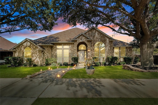 single story home with a front yard and stone siding