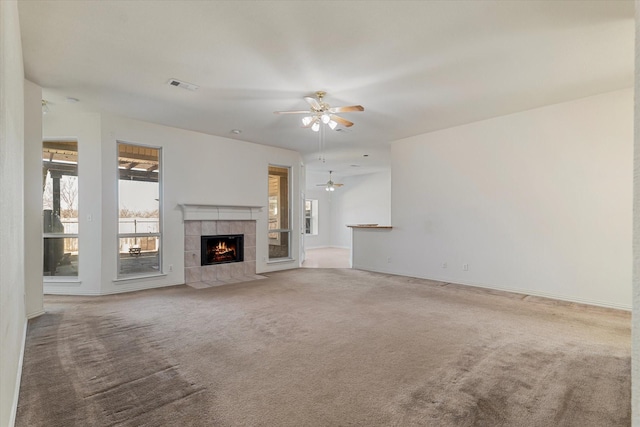 unfurnished living room featuring visible vents, a ceiling fan, carpet flooring, a fireplace, and baseboards