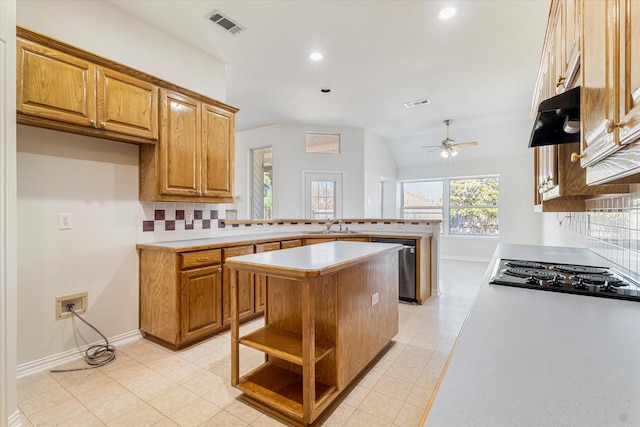 kitchen with visible vents, a peninsula, under cabinet range hood, stainless steel dishwasher, and black electric cooktop