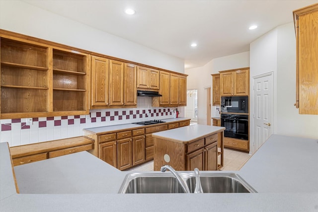 kitchen with black appliances, under cabinet range hood, a sink, a kitchen island, and tasteful backsplash