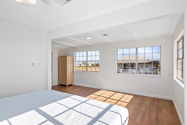 unfurnished bedroom with visible vents, baseboards, and wood finished floors