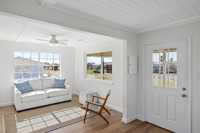 foyer entrance featuring crown molding, wood finished floors, and baseboards