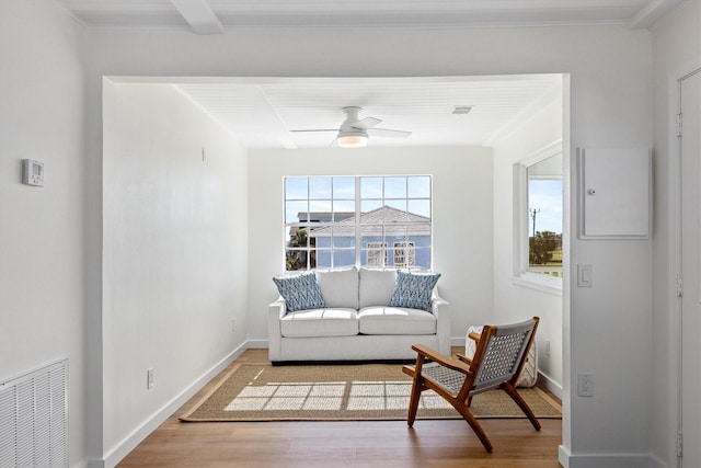 sitting room with a wealth of natural light, visible vents, a ceiling fan, and wood finished floors