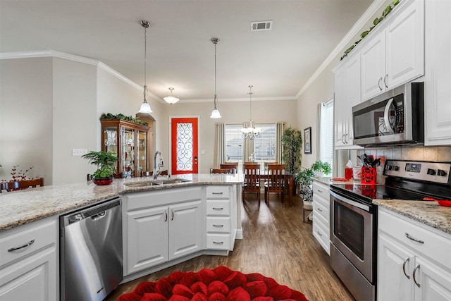 kitchen featuring dark wood-style floors, a sink, white cabinets, appliances with stainless steel finishes, and backsplash