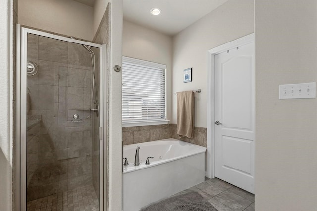 bathroom with a stall shower and a bath