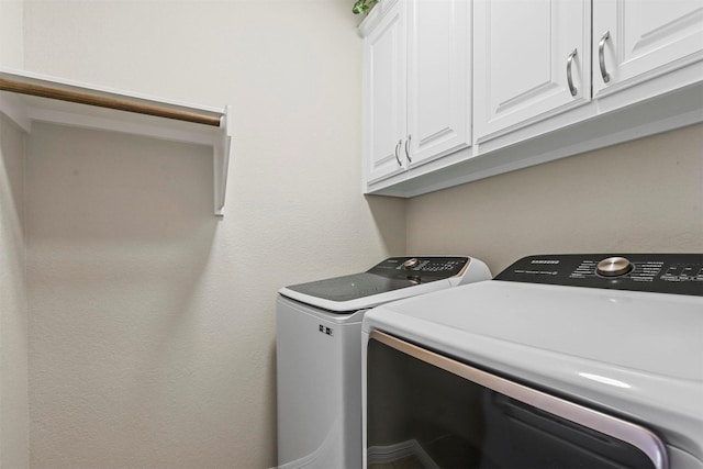 washroom with cabinet space and washer and clothes dryer