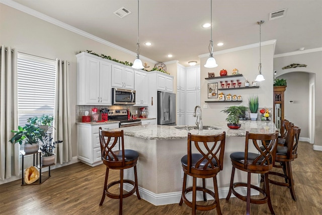 kitchen featuring a sink, visible vents, arched walkways, and appliances with stainless steel finishes