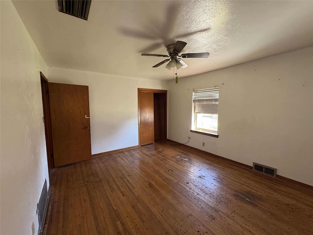 unfurnished room featuring ceiling fan, visible vents, and hardwood / wood-style floors