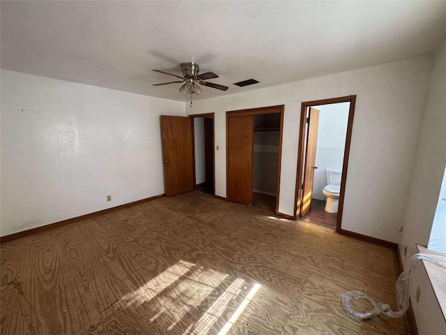 unfurnished bedroom featuring a ceiling fan, visible vents, baseboards, ensuite bath, and a closet