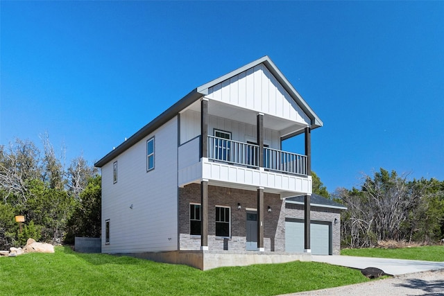 view of front of home featuring brick siding, board and batten siding, a front yard, a balcony, and driveway