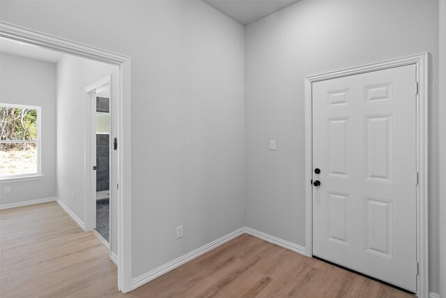 foyer with light wood-style flooring and baseboards
