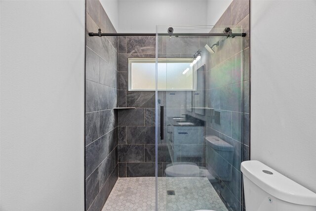 bathroom featuring toilet and a stall shower