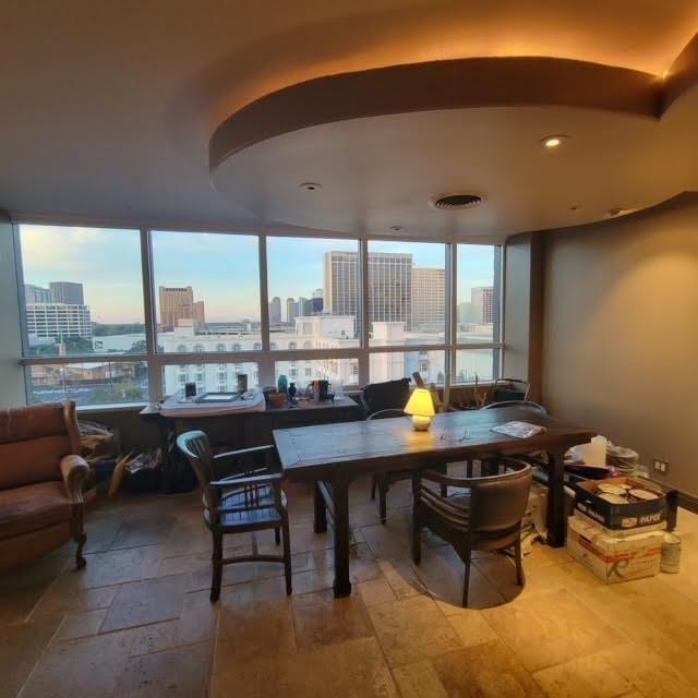 dining room featuring a view of city, arched walkways, and stone tile flooring