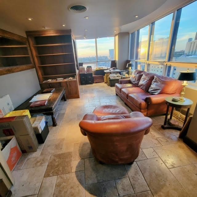 living room with visible vents, a view of city, and stone tile floors