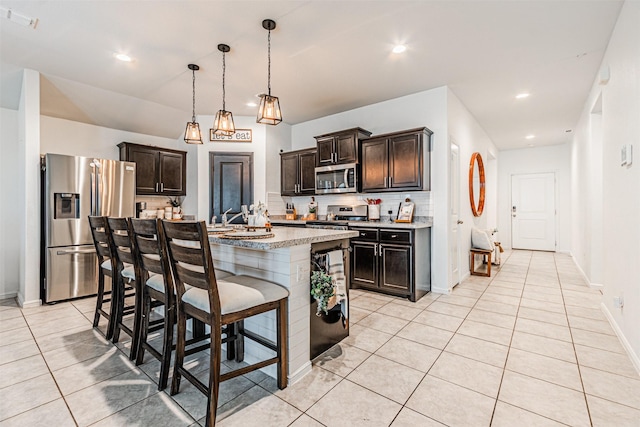 kitchen with light tile patterned floors, backsplash, appliances with stainless steel finishes, and dark brown cabinets