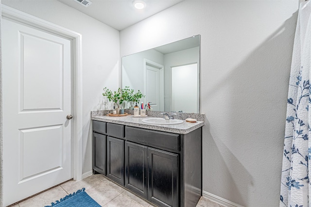 full bathroom featuring tile patterned floors, baseboards, and vanity