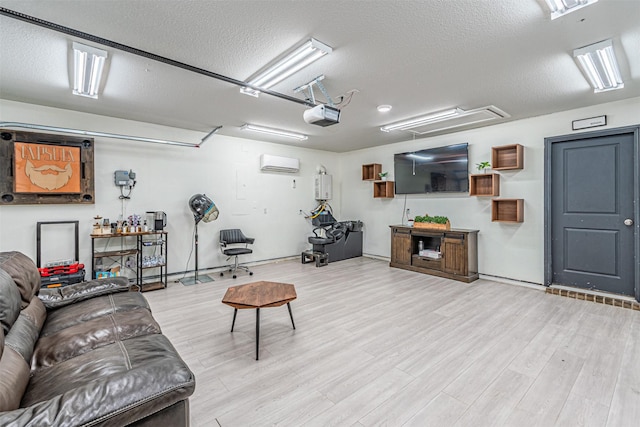 living room with a wall unit AC, wood finished floors, attic access, a garage, and a textured ceiling