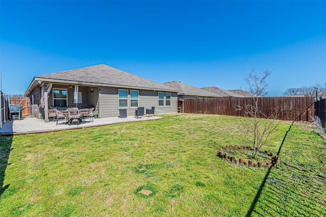 rear view of house featuring a yard, a patio, and a fenced backyard