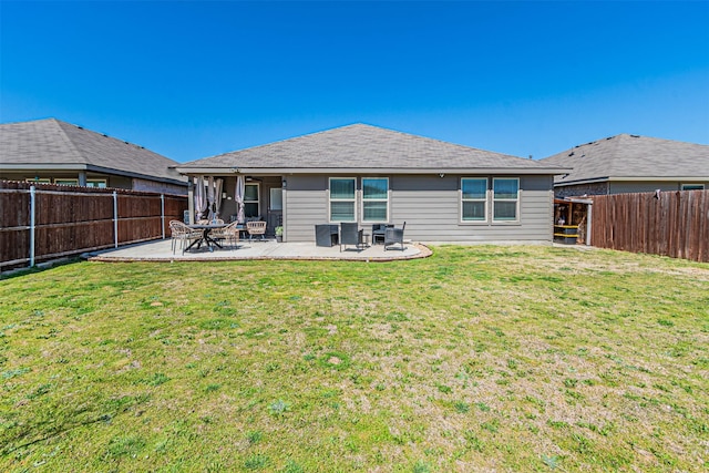 back of house with a patio, a yard, and a fenced backyard