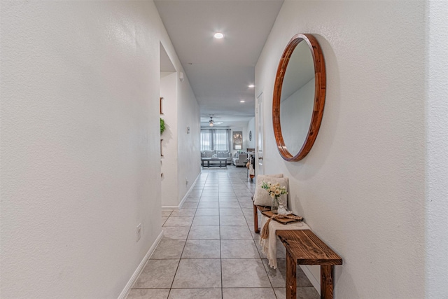 hall with light tile patterned floors, baseboards, and recessed lighting