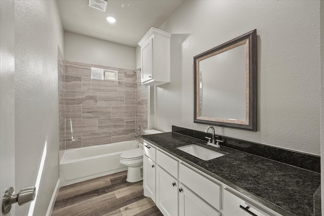 bathroom with vanity, wood finished floors, visible vents, shower / bath combination, and toilet